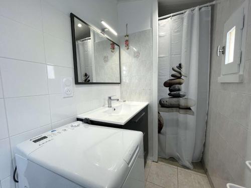 une salle de bain blanche avec un lavabo et des toilettes dans l'établissement Petite maison rénovée près de la mer avec piscine chauffée, tennis et patio - Bretignolles-sur-Mer - FR-1-224A-55, à Bretignolles-sur-Mer