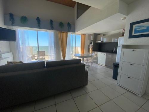 un salon avec un canapé et une grande fenêtre dans l'établissement Duplex pour 6 avec vue océan, balcon et garage privatif - FR-1-494-131, à Royan