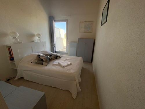 ein weißes Schlafzimmer mit einem Bett und einem Fenster in der Unterkunft Duplex pour 6 avec vue océan, balcon et garage privatif - FR-1-494-131 in Royan