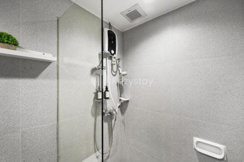 a shower with a glass door in a bathroom at PECAN by Kozystay - Sudirman in Jakarta