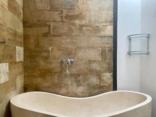 VILLA LUNA في كيروبوكان: حوض استحمام في الحمام بجدار حجري