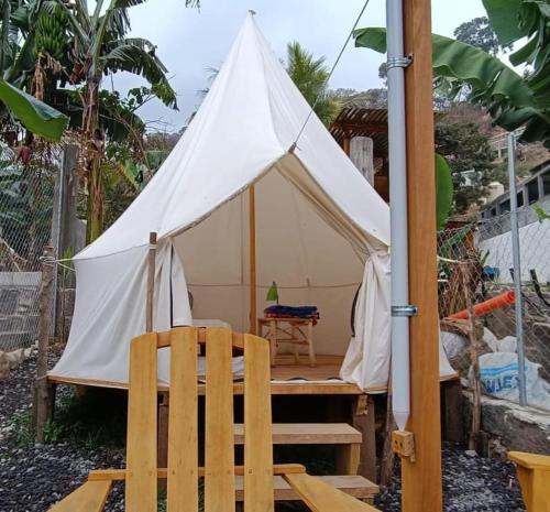 a white tent with a chair and a table at Tipis Ya' in San Pedro La Laguna