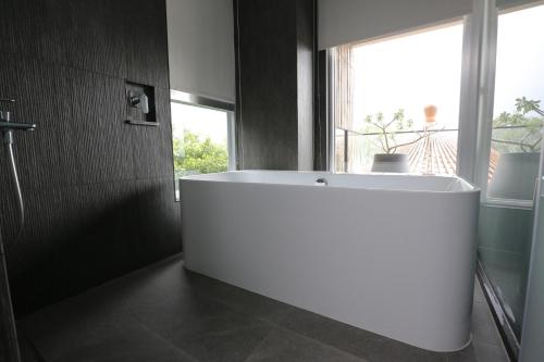 a white bath tub in a bathroom with a window at Hotelday Sun Moon Lake in Yuchi