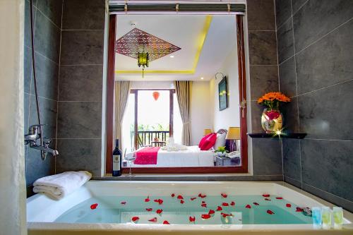 1 dormitorio y baño con bañera y espejo. en Rural Scene Villa, en Hoi An