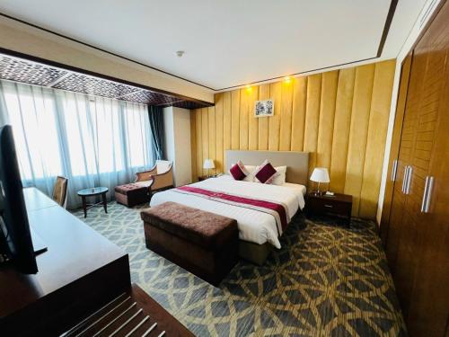 a hotel room with a large bed and a couch at Le Indochina Hotel in Bắc Ninh