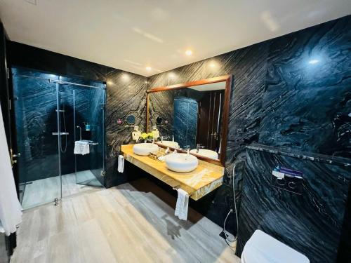 a bathroom with two sinks and a shower at Le Indochina Hotel in Bắc Ninh