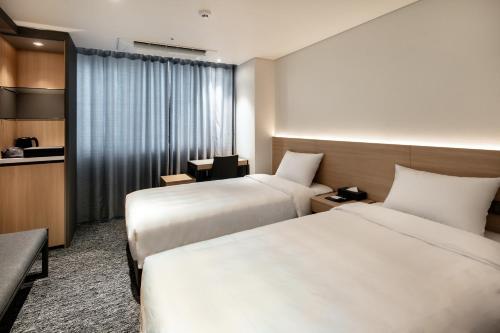 Ένα ή περισσότερα κρεβάτια σε δωμάτιο στο Icheon Skysun Hotel