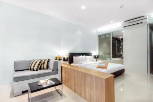 a bedroom with a bed and a couch at Mida De Sea Hua Hin - SHA PLUS in Cha Am