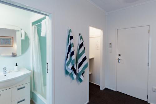 a bathroom with a sink and a mirror at Aotearoa Lodge in Whitianga