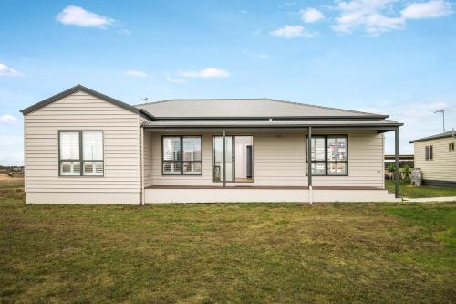 a white house with a gray roof at The Oxley Estate in Portarlington