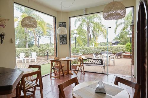 a restaurant with tables and chairs and a large window at Hotel Termas Day in Termas del Daymán