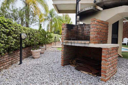 a brick fireplace in a yard next to a house at Hotel Termas Day in Termas del Daymán