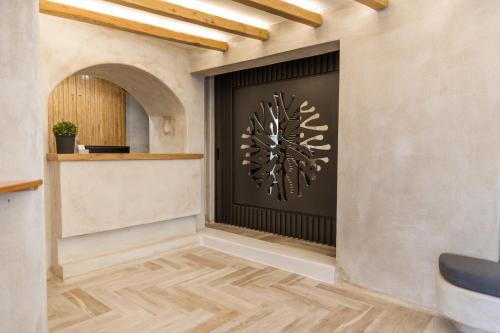a lobby with a black door with a tree wall art at Korali Palace Hotel in Naxos Chora