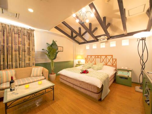 a bedroom with a bed and a couch and a table at Hotel Rocco (Adult Only) in Nara