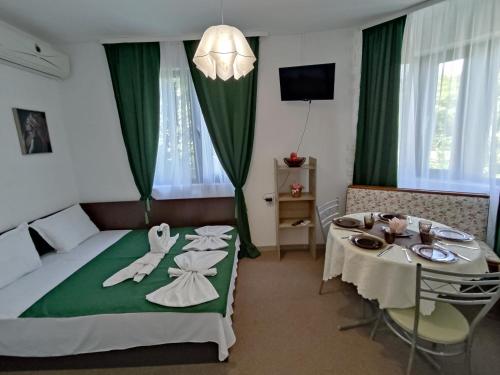 een hotelkamer met een bed en een tafel met stoelen bij Rali Apartments in Kiten