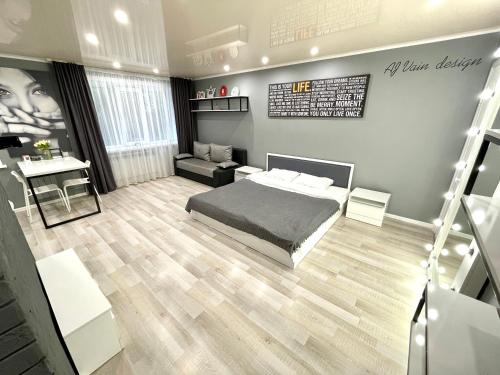 Un dormitorio con una cama, un sofá y un escritorio. en Квартира-студия в центре с белым постельным, идеально чиcтая, с большим зеркалом, en Petropavlovsk