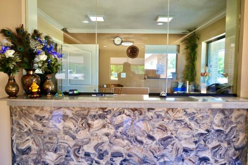 a lobby with a counter with flowers on it at Regency Inn & Suites in Gladewater