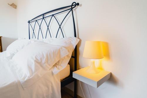 a bedroom with a bed with a lamp on a night stand at Villa Tina ai Piedi del Faro di Leuca in Leuca