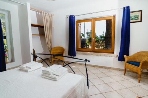 Pokój z łóżkiem, krzesłami i oknem w obiekcie Villa Tina ai Piedi del Faro di Leuca w mieście Leuca