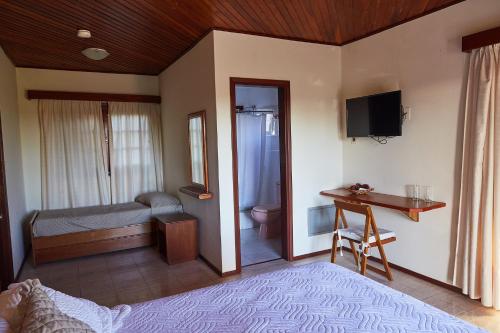 a room with a bedroom with a bed and a desk at Hotel Termas Day in Termas del Daymán