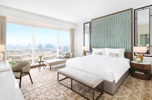 a bedroom with a large white bed and a large window at Sofitel Dubai The Obelisk in Dubai