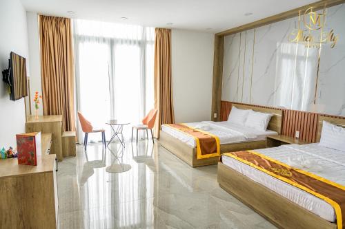 a hotel room with two beds and a table at Khách Sạn Thiên Mỹ in Rach Gia