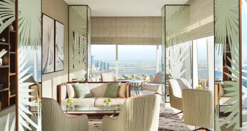 a living room with a couch and a table and chairs at Sofitel Dubai The Obelisk in Dubai