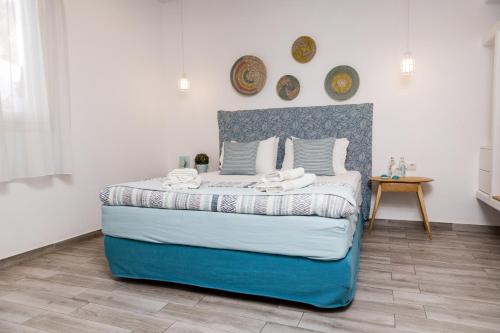 a bedroom with a blue and white bed and a table at Korali Hotel in Naxos Chora