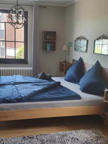 a bedroom with a bed with blue sheets and a window at Haylees Hus 2 in Kellenhusen