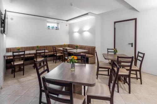 a restaurant with tables and chairs and a white wall at Šiaurės Vartai in Joniškis