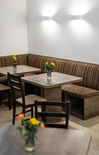 two tables and a couch in a restaurant at Šiaurės Vartai in Joniškis