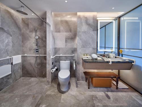 a bathroom with a toilet and a sink and a shower at Doubletree By Hilton Yancheng Dayangwan in Yancheng