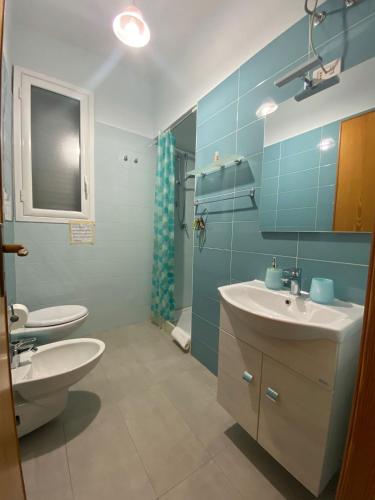 a bathroom with a sink and a toilet and a mirror at Villetta sullo Scoglio in Gela