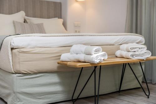 a bed with towels on a table in a room at Korali Hotel in Naxos Chora