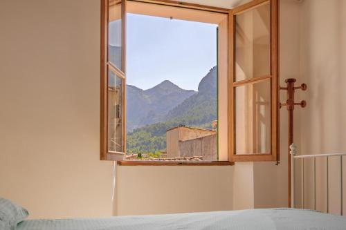 a window in a bedroom with a view of a mountain at Cas Pobres in Sóller