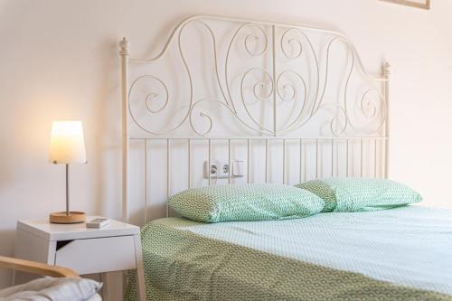a bed with a white headboard and two pillows at Cas Pobres in Sóller