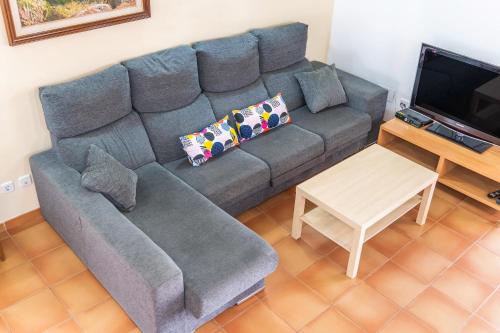 a living room with a gray couch and a table at Cas Pobres in Sóller