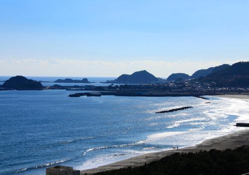 a view of a beach with mountains in the distance at Kamogawa Grand Tower in Kamogawa