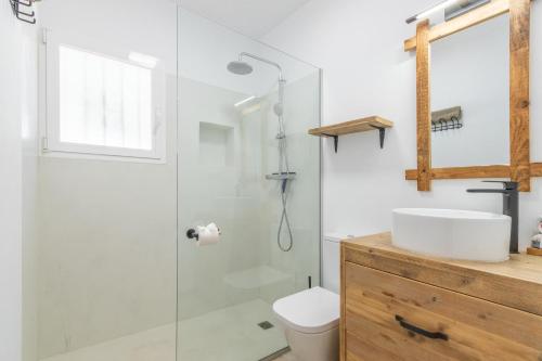 een badkamer met een glazen douche en een wastafel bij Villa with private Heated pool in Casas de Torrat