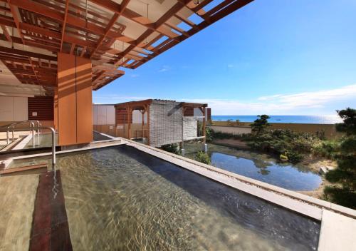 an outdoor swimming pool with a view of the ocean at Kamogawa Grand Tower in Kamogawa