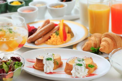 a table with two plates of breakfast foods and drinks at Atsugi Urban Hotel in Atsugi