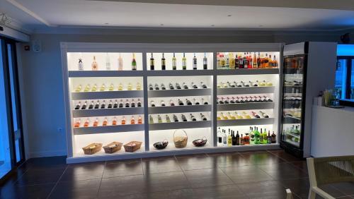 a display case filled with lots of wine bottles at Palatino Hotel in Parga