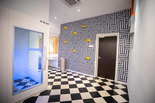 a bathroom with a black and white checkered floor at Le Embassy Hotel Georgetown in George Town