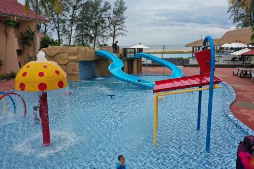 ein Pool mit Wasserrutsche in einem Resort in der Unterkunft Holiday Villa Beach Resort Cherating in Cherating