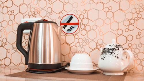 a kettle and a tea pot on a table at Reikartz Kokand in Kokand