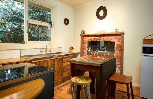 a kitchen with a brick fireplace and a sink at Koko Guesthouse - Two bedroom Option in Olinda