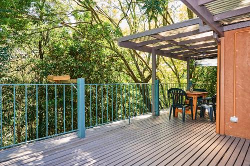 a wooden deck with a table and chairs on it at Koko Guesthouse - Two bedroom Option in Olinda