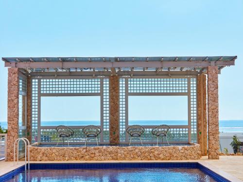a pool with chairs and a view of the ocean at HOTEL SEABREEZE CORAL in Miyako-jima
