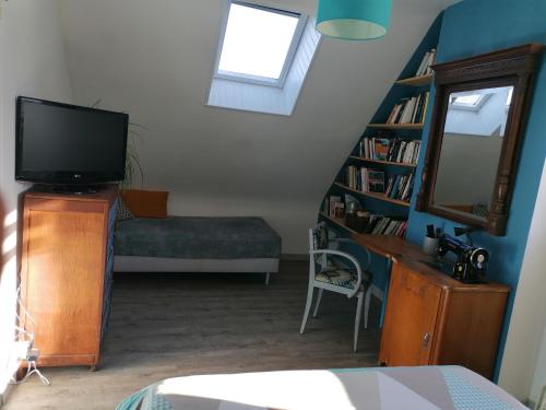 uma sala de estar com televisão e uma escada em Chez Jak et Laurent em Quéven