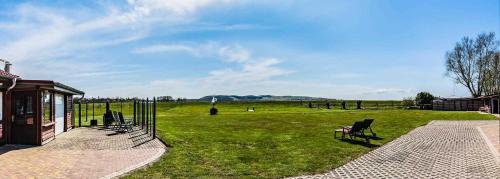 um grupo de cadeiras sentadas num campo de relva em schöne Ferienwohnungen am Lobber Deich em Lobbe